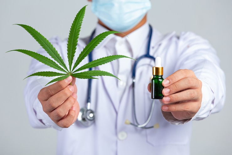 medical-doctor-holding-cannabis-leaf-bottle-cannabis-oil-white-wall_1150-26701.jpg