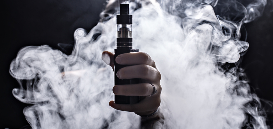 vaping-person-holding-vape-surrounded-by-smoke.png